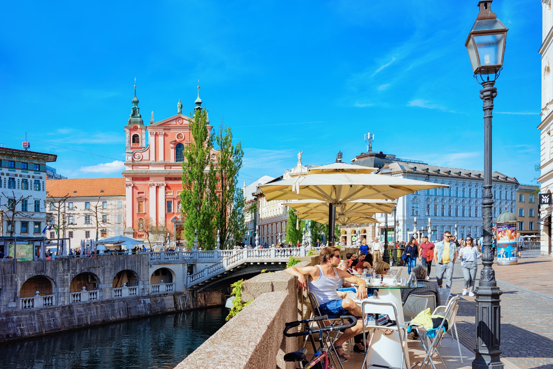 Ljubljana’da, Ljubljanica Nehri üzerindeki Üçlü Köprü’de bir sokak kafesinde oturan insanlar